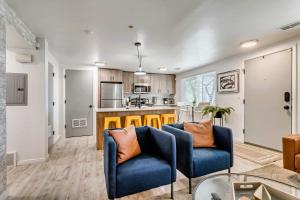 a living room with two blue chairs and a kitchen at Close to Downtown - K and Q Beds - Parking in Salt Lake City