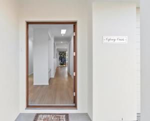 um corredor com uma porta de vidro e um corredor que conduz a um corredor em Osprey Oasis em Banksia Beach