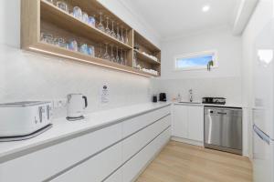 a kitchen with white cabinets and a counter top at Osprey Oasis in Banksia Beach