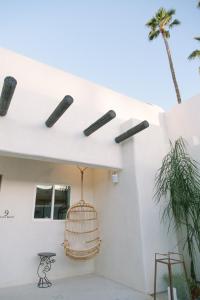 una casa bianca con una gabbia per uccelli sul lato. di Yara Hotel - Adults Only a Palm Springs
