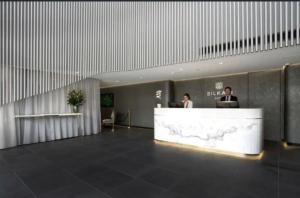 two people sitting at a reception desk in a lobby at Broad Land Premium Apartments Chatswood Sydney in Sydney