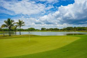 a golf course with a lake and palm trees at Modern - Marina View Balcony - Exquisite Pool - Sleeps 6 in Boca de Río Hato