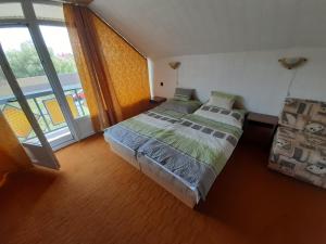 1 dormitorio con cama y ventana grande en Eliza nyaraló en Balatonmáriafürdő