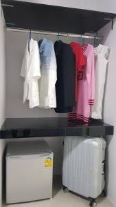 a closet with shirts and a suitcase on a shelf at ซีนายเฮ้าส์ Z9 House in Ban Kao