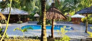 a swimming pool in a resort with palm trees at Denika's Suites in Puerto Princesa City