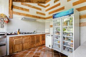uma cozinha com armários de madeira e um frigorífico em Bajalo Cottage Canggu em Canggu