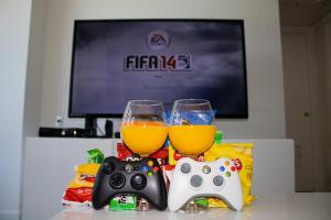 two glasses of beer and a video game controller at Oceanfront Condo - Ocean Views, Pool, Gym Hollywood Beach in Hollywood