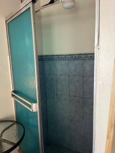 y baño con ducha y puerta de cristal. en El mochilero en Cartago