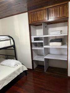 a bedroom with a bunk bed and white shelves at El mochilero in Cartago