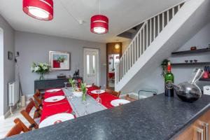 uma sala de jantar com uma mesa com uma toalha de mesa vermelha em iStay Here Ltd - 1 Bed House with Wifi and Parking - An African Adventure em Aston End