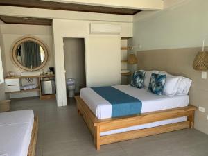 1 dormitorio con 1 cama grande y espejo en Oasis Tolú Hotel Boutique, en Tolú