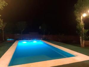 a swimming pool at night with a street light at Cabañas cerella in Puerto Iguazú