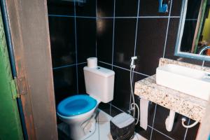 uma casa de banho com um WC azul e um lavatório. em Morango das Palmas em Praia de Palmas