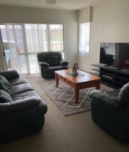 a living room with two couches and a coffee table at Home away from home air b and b in Whangarei