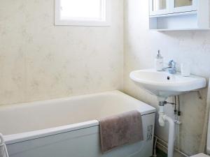 a bathroom with a sink and a bath tub and a sink at Holiday home HÄLLEVADSHOLM II in Hällevadsholm