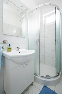 y baño blanco con lavabo y ducha. en Apartments by the sea Tkon, Pasman - 17360, en Tkon
