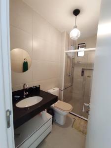 a bathroom with a sink and a toilet and a mirror at Sweet home in Maceió