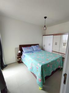 a bedroom with a bed with a green blanket on it at Sweet home in Maceió