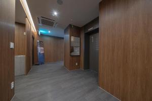 einen Flur mit Holzvertäfelung und einen Flur mit Türen in der Unterkunft Aank Hotel Daejeon Yuseongonsen 1st in Daejeon