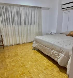 a bedroom with a bed and a wooden floor at Depto cómodo, ubicación perfecta in Pergamino