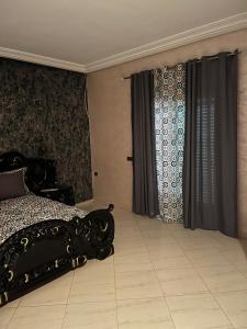 una camera con letto e tende neri di Appartement centre-ville a Fes