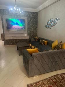 un soggiorno con divano e TV a schermo piatto di Appartement centre-ville a Fes