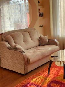 a brown couch in a living room with a table at Квартира in Almaty
