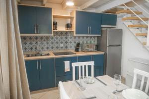 a kitchen with blue cabinets and a table with chairs at Sueño al Mar Residence & Hotel in Potrero