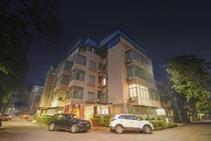 a building with two cars parked in front of it at Townhouse Hotel The Platinum in Pātipukur