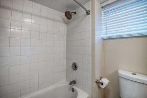 a white bathroom with a tub and a toilet at Kailua Village 5th floor - View of Kailua Bay KV506 in Kailua-Kona +7 photos