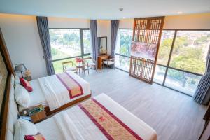 a hotel room with two beds and a large window at MT Collection Hotel in Ninh Binh +38 photos