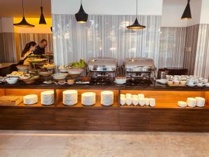 a buffet line with plates and food in a restaurant at Liberty Hotel Saigon Greenview in Ho Chi Minh City
