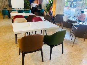 a table and chairs in a restaurant with people sitting at tables at Liberty Hotel Saigon Greenview in Ho Chi Minh City