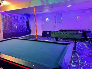 a pool table in a room with purple lighting at Bigfoot Bungalow in Logan
