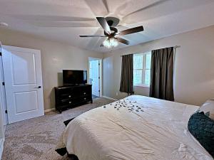 - une chambre avec un lit et un ventilateur de plafond dans l'établissement Bigfoot Bungalow, à Logan