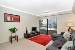 a living room with a couch and a tv at BAR09- 1 bedroom unit In Heart of Cremorne in Sydney