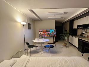 Habitación con mesa, sillas y cocina. en Mi Stay - StarBnB branch, en Daegu