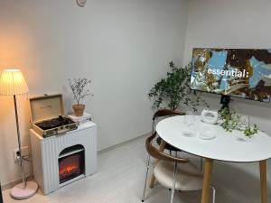 a dining room with a table and a fireplace at Mi Stay - StarBnB branch in Daegu