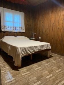 a bedroom with a large bed with a window at Los Bananos - Big Wood Cabin in Puerto Iguazú +32 photos