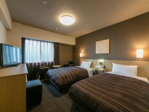 ein Hotelzimmer mit 2 Betten und einem Flachbild-TV in der Unterkunft Hotel Route-Inn Kumamoto Ekimae in Kumamoto