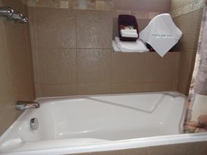 y baño con bañera blanca y lavamanos. en Hostal San Juan, en Quito