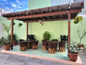 un patio con mesas y sillas bajo una pérgola en Villa Guadalupe en Chapala