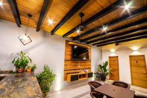 a living room with wooden ceilings and a table and chairs at Villa Guadalupe in Chapala