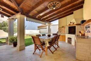 a kitchen with a wooden ceiling and a table and chairs at Villa Villetta Valtura in Ližnjan