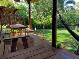 - une terrasse couverte avec un hamac, une table et un banc dans l'établissement Los Bananos - Big Wood Cabin, à Puerto Iguazú