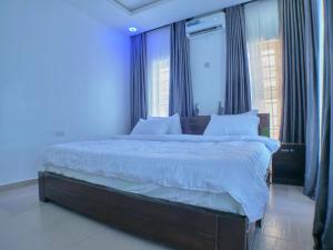 sypialnia z dużym łóżkiem z niebieskimi ścianami w obiekcie Vacvilla Shortlets 