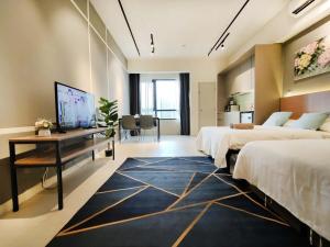 ein Hotelzimmer mit 2 Betten, einem Schreibtisch und einem Zimmer in der Unterkunft Tamarind Suites Cyberjaya in Cyberjaya