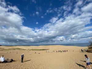 a group of people standing in the sand in the desert at GNARLY OWL in Shikano +12 photos