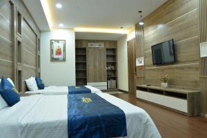 邦美蜀Huyen Nga Hotel的一间带床和电视的酒店房间