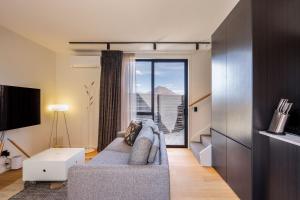 a living room with a couch and a large window at Remarkables View, 1BDR, Wi-Fi in Frankton Wharf